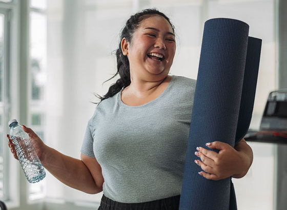 Woman managing diabetes in the workplace, wrapping up yoga mat