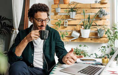 a WFH employee sits in comfortable surroundings that improve his well-being, work from home, remote work and hybrid work